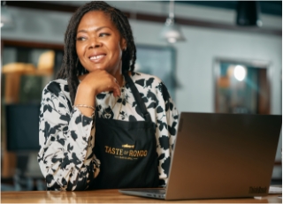 taste-of-rondo-woman-in-apron-smiling-with-laptop